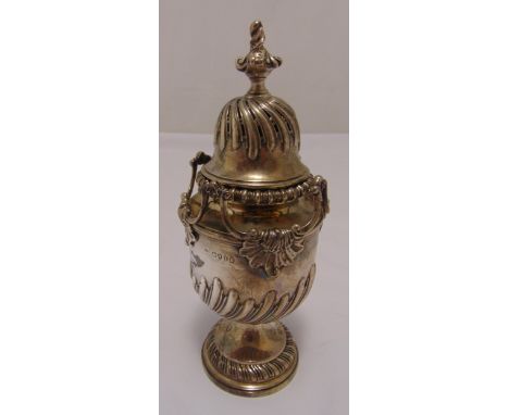 A Victorian hallmarked silver sugar castor part spirally fluted vase form with shell mounted scrolling sides on raised circul