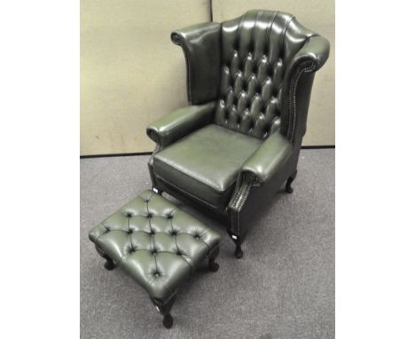 A dark green wingback armchair with button back, approximately 105cm high, together with matching footstool
