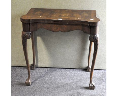 A 20th century walnut folding card table, in the Georgian style, on carved cabriole legs with claw and ball feet, 74 cm high 