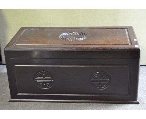 A Chinese hardwood coffer with hinged cover, with carved seal ornament, 48 cm high x 103.5 cm wide x 52 cm deep