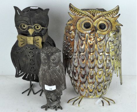 A group of three metal figures of owls, one as a solar light, another a candle holder