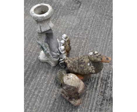 Three stone garden ornaments, a large duck and owl together with a figure of a hedgehog and a plant stand, largest 61cm high