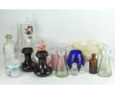 A collection of various glassware, including an empty poison bottle, Galileo thermometer and more