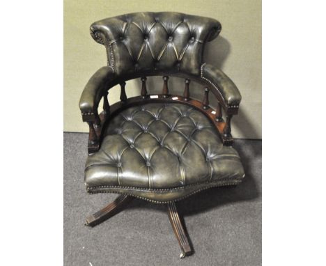 A 20th century Captain's chair, upholstered in green leather style fabric, button backed and  applied with studs, with balust