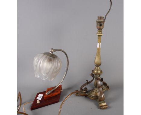 A 19th Century brass candlestick, fitted as a table lamp, on tripod base, and an Art Deco desk lamp with frosted waterlily sh