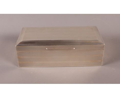 An engine turned silver table cigarette box, 7" long