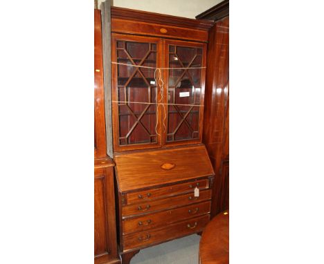 An Edwardian mahogany and satinwood banded bureau bookcase enclosed two doors over four graduated long drawers, on bracket fe