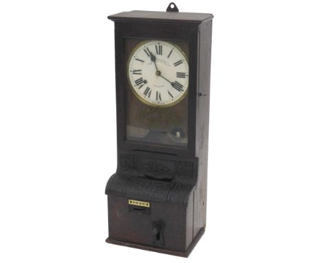 A Blick time recorder, the white enamel style dial with Roman numerals, behind a glass door with stencil decoration Blick-Tim
