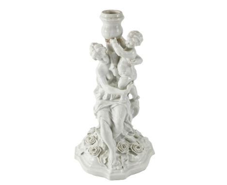 A Dresden porcelain figural candlestick, the shaped base with flower encrusted decoration, underglaze R mark to underside, 30