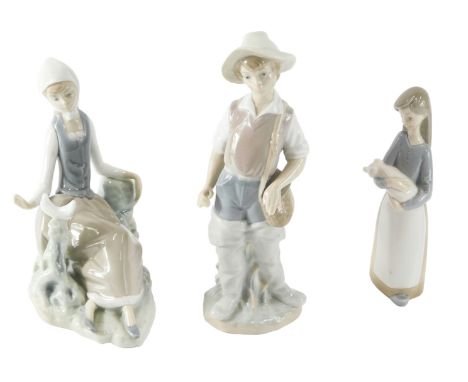 A Lladro porcelain figure of a seated lady, wearing a scarf, 15cm long, another figure of a fisherman, and a figure of a youn