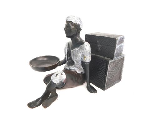 A cold painted bronze figure, of an Arab seated beside suitcases, 12cm high.