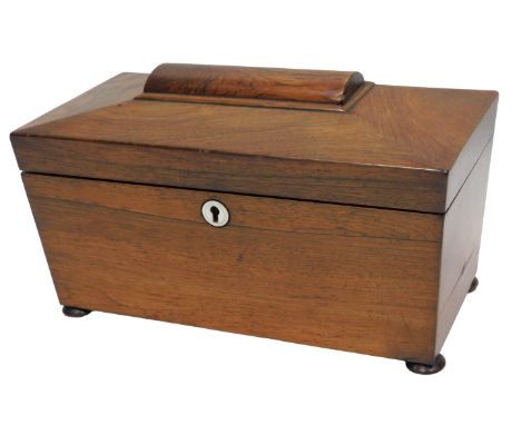An early 19thC rosewood sarcophagus shaped tea caddy, the hinged lid enclosing two lidded divisions, on bun feet, 30cm wide. 