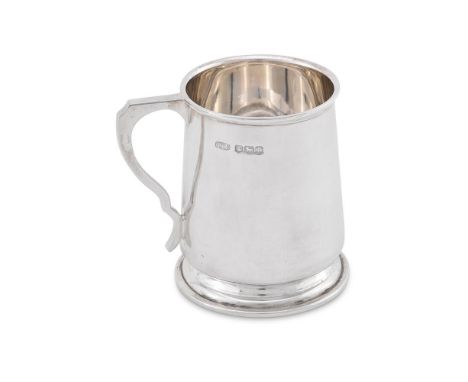 A SILVER OVOID FOOTED PINT MUG 
WALKER &amp; HALL, SHEFFIELD 1932 
With a moulded rom, a tongue-capped S-scroll handle and a 