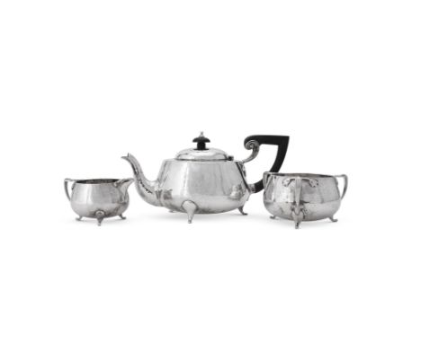 
	
		AN ARTS AND CRAFTS HAMMERED SILVER THREE PIECE TEA SERVICE 
		BARKER BROTHERS, CHESTER 1923 
		The tea pot with a compos