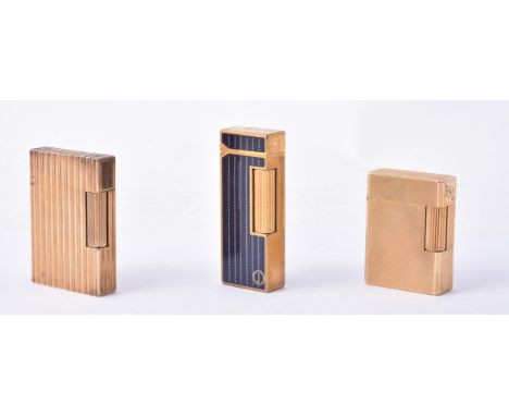 
	
		DUNHILL, A GOLD PLATED GAS LIGHTER
		Black lacquered with white 'stitching', 6.5cm (2 3/4in) high; and S. T. Dupont, two