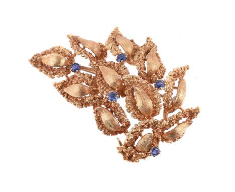 
	
		A 1960S SAPPHIRE BROOCH
		The brooch with textured pear shaped panels and circular cut sapphire accents, stamped 750
		S