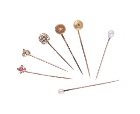 
	
		A COLLECTION OF EARLY 20TH CENTURY STICKPINS
		To include a pierced scrolled diamond and half pearl set stick pin, stamp