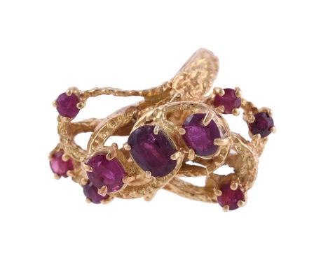 
	
		A RUBY DRESS RING 
		LONDON 1973 IMPORT MARK
		The spiralling textured panel ring set with various oval and circular cut