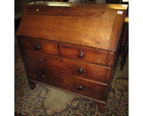 Early 19th Century oak bureau having two short and two long drawers, with knob handles on bracket feet.
