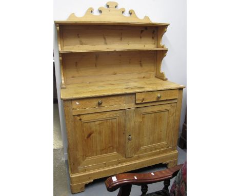 Pine two stage rack back dresser with an arrangement of drawers on bracket feet.