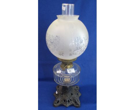 Brass double burner oil lamp with pillar cut glass reservoir on a cast foliate pierced metal base, having etched glass shade 