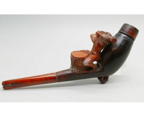 A 19th Century carved Meerschaum pipe depicting a monkey playing a drum, amber stem, cased 