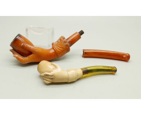 Two hand carved Meerschaum pipes in the form of a lady's hand in glove, the larger pipe with broken amber stem, both cased 