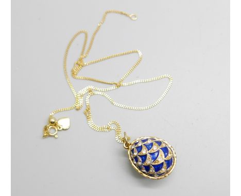 A Faberge style silver gilt and enamel egg pendant and chain 