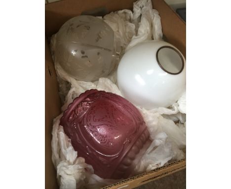 Three glass light shades - one cranberry with flower motif in centre panels, one milk glass, and one with etched flower motif