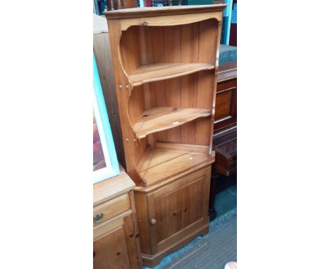 An Ercol pine corner cabinet. 