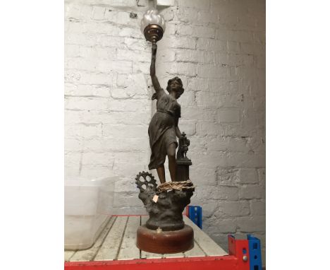 A metal figural table lamp in shape of a woman holding flame in hand.Left hand was supposed to be attached to the lever of th