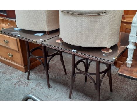 A pair of Lloyd Loom glass top tables. 