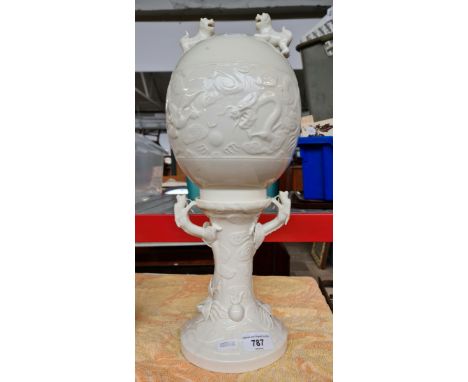 A Chinese lamp base decorated with dragons and foo dogs.