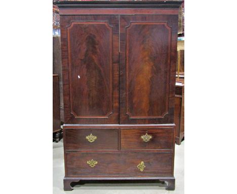 A Georgian mahogany linen press, the upper section enclosed by  a pair of well matched flame veneered panelled doors with cro