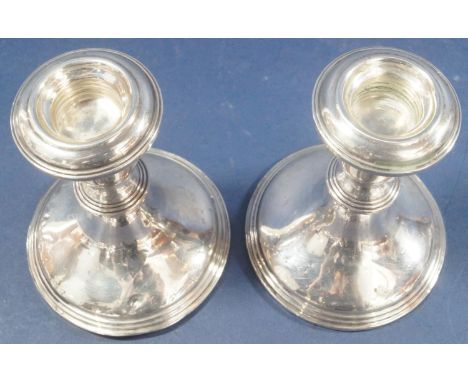 A pair of silver squat candlesticks stamped 'Sterling Silver' to base, 12cm high 