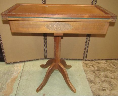 An Indian hardwood card table of rectangular form with foldover top, raised on a slender hexagonal column and quadruped base 