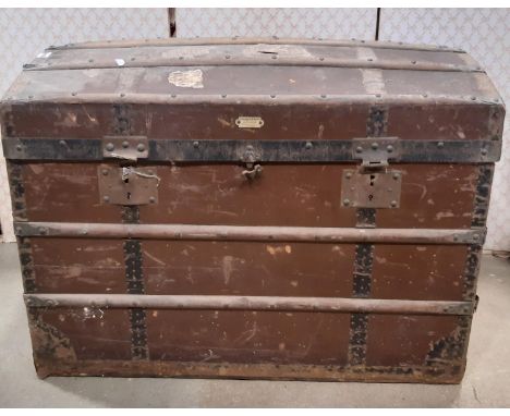 A vintage travel trunk with arched lid and timber lathes 