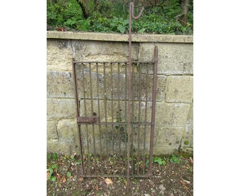 A small old wrought iron gate 58cm wide x 106cm high, together with an iron pig tail stake (2) 