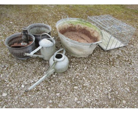 A vintage oval galvanised steel two handled bath, two galvanised watering cans of varying design, pair of weathered fluted ci