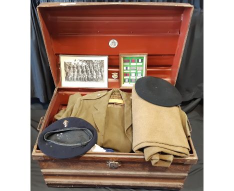 A vintage tin trunk with scumble finish containing a collection of WW2 and late 40's military clothing and ephemera mostly re