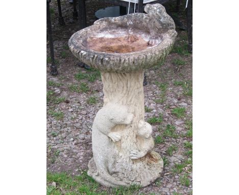 A weathered contemporary naturalist two sectional bird bath, the simulated tree trunk pedestal with otter surround, 68cm high