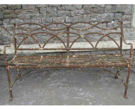 A weathered Regency iron garden bench with strap work seat, lattice back and open arms, (af), 156 cm wide 