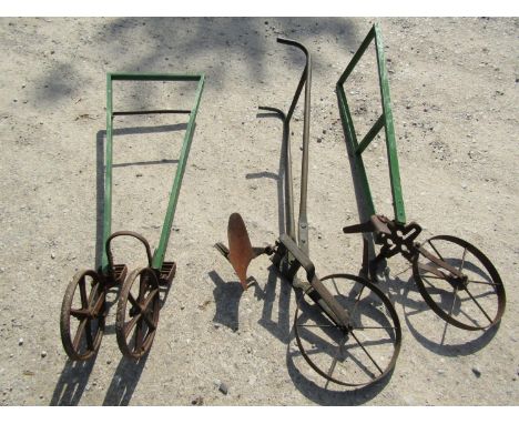 A vintage push hoe and plough with iron spoke wheels, one with tubular metal handle, the other painted wooden, together with 
