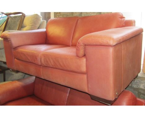 A Natuzzi Italia three seat sofa with stitched faded red leather upholstered finish with loose cushions  together with a matc