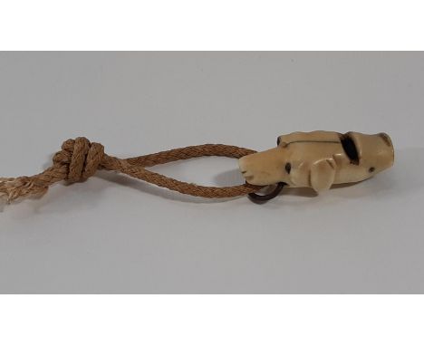 A 19th century bone dog whistle in the shape of a hounds head with beaded eyes and metal ring to mouth. 4cm.