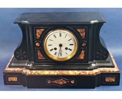 A Victorian black slate and polished marble mantle clock with shaped outline and enamel dial enclosing an eight day striking 