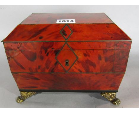 A Georgian tortoiseshell tea caddy in sarcophagus form with brass stringing, raised on gilt paw feet. 