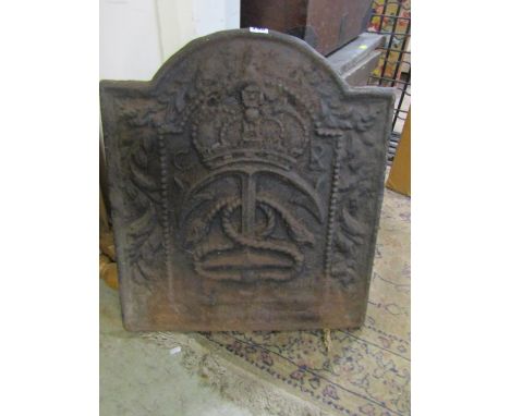 A heavy vintage cast iron fireback of stepped arched form with crown and anchor detail within a floral border, 54cm wide x 62