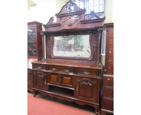 A substantial late Victorian period sideboard, the lower section enclosed by an arrangement of cupboards and drawers, the rai