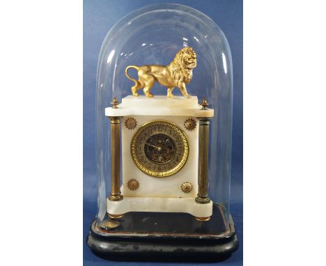 A mid-Victorian period mantle clock with white alabaster case and applied brass column supports, surmounted by a gilded lion,